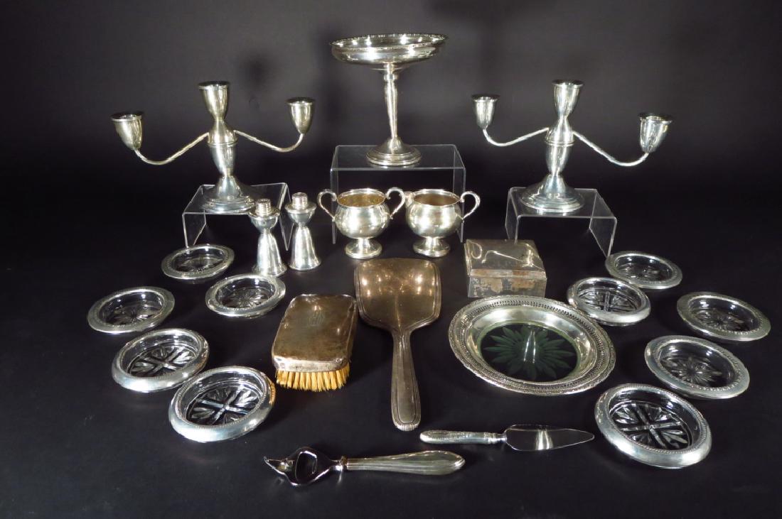 Lot of Weighted Sterling Silver Items: Lot of weighted sterling silver items . Comprising a creamer and sugar,10 sterling rimmed coasters, a wine coaster,compote, caplifter, cheese knife, mirror, brush,cigarette box and a pair of candlesti