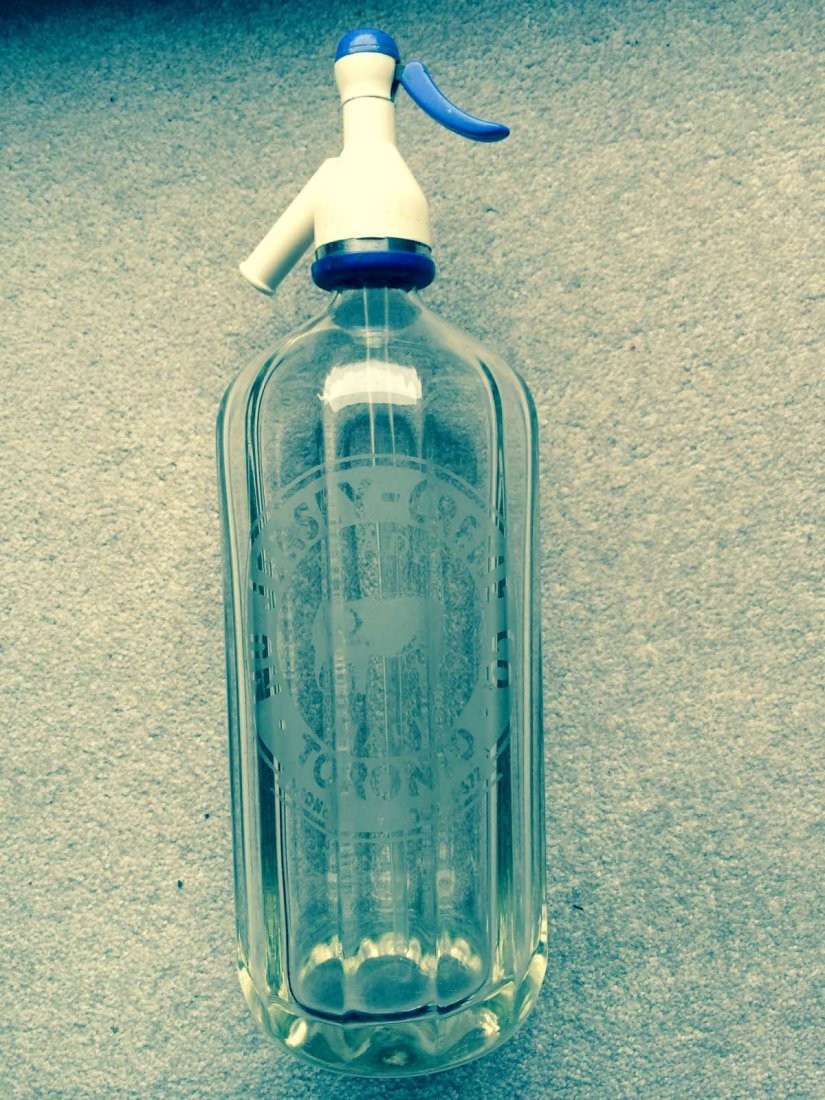 Seltzer Bottle: Clear glass seltzer bottle by Nu Jersey-Creme Co.,Toronto with elephant trademark. In excellent condition it retains its original plastic siphon made in England and stamped Nu Jersey-Creme Toronto