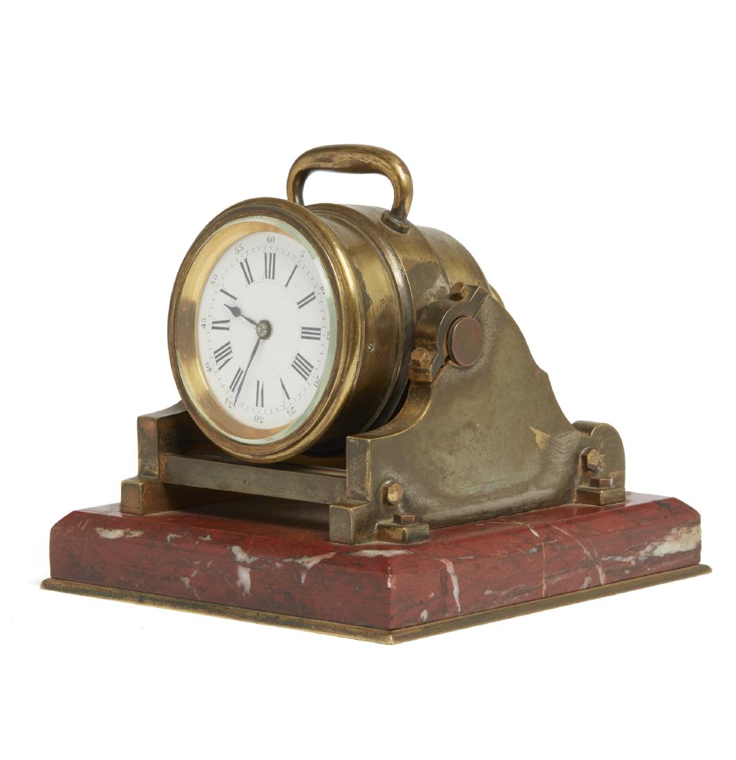 Industrial Style Mortar Clock: Industrial style mortar clad on a rouge griotte base. Modeled as a mortar in gilt bronze resting in a cradle with a rotating axle. White enamel dial with Roman numerals. Dimensions: (overall) 5.12"h x