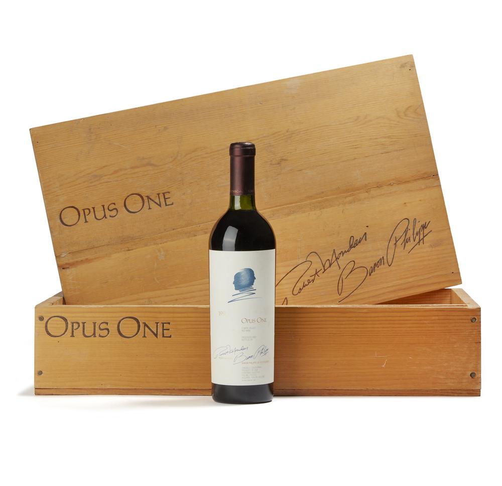 1990 Opus One Wine: One bottle of 1990 Opus One red wine in wood box. Opus One is a joint venture between the Robert Mondavi Winery and Baron de Rothschild S.A. Processing and shipping within the continental U.S. $40.00 