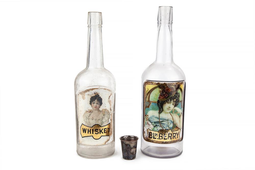 Label Under Glass Whiskey and Black Berry Bottles: Lot of two label under glass liquor bottles: "Blk. Berry" (12'h) and "Whiskey" (11.5"h). Processing and shipping within the continental U.S. $55.00 plus 1.5% replacement cost insurance.Ê