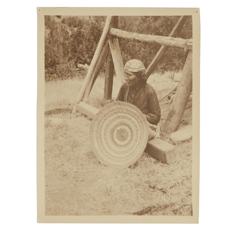 Grace Nicholson Photograph of Karok Indian Basket Maker: Photograph of Karok Indian basket maker, Northwest California by Grace Nicholson. Handwritten in ink description verso. Stamped, verso, "Photo by Grace Nicholson, Pasadena, Cal." Dimensions: (overall)