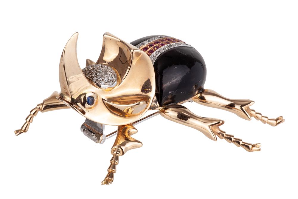 Diamond Sapphire Ruby 18k Beetle Brooch: 18k beetle brooch with sapphire eyes and accented with rubies (1 ct TW) and diamonds (1 ct TW / I1 / GH). Black body is an unknown molded surface, possibly glass. Total gross weight: 66.86 grams. Dime