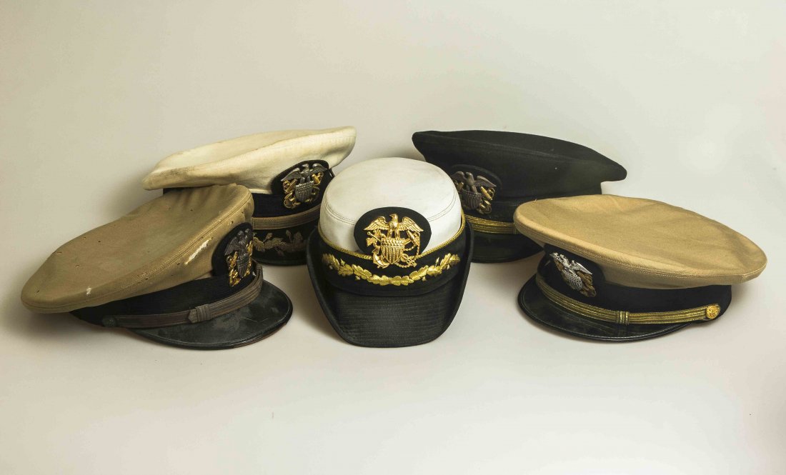 5 U.S. Navy Officers' Hats: White top with “scrambled eggs” named to Cdr. Rod Marshall. Top is spotted, badge is 1/20th 20k gold filled; Blue top cap in extremely nice shape, sterling badge; Khaki top in very good shape name