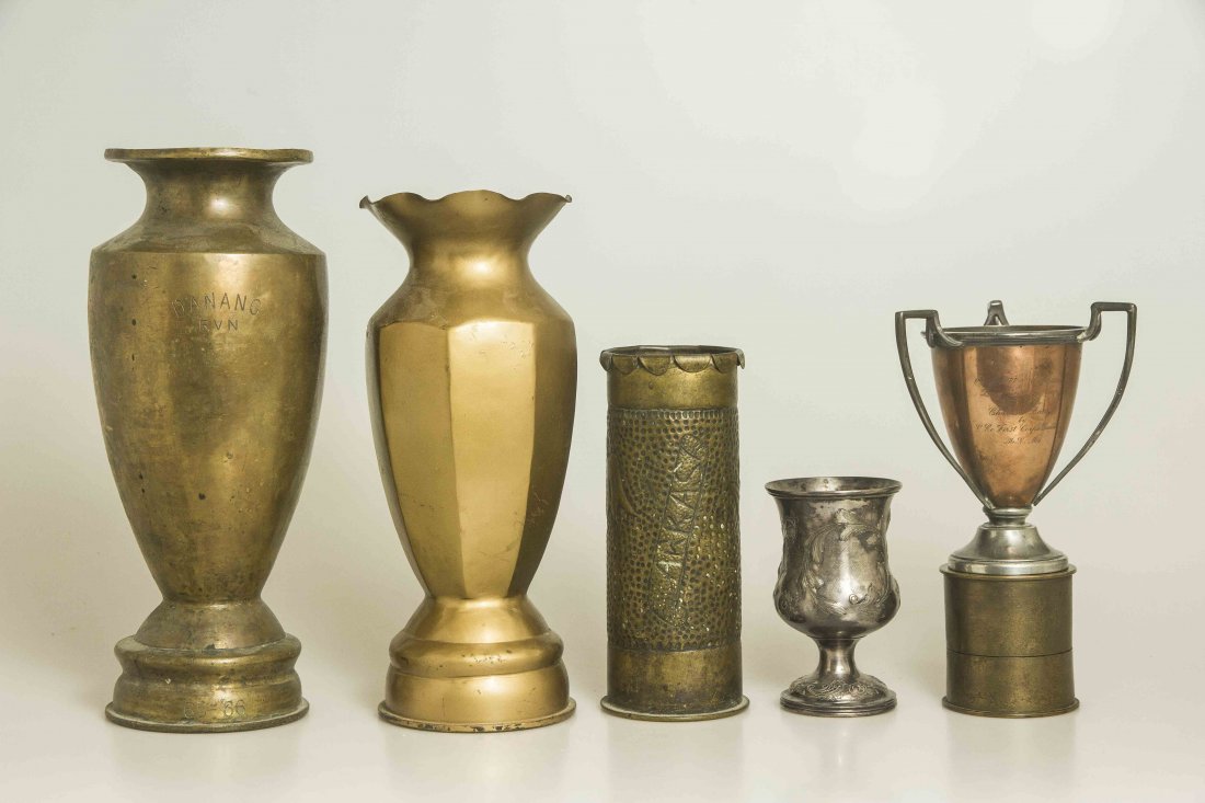 Group of Military Trophies and WWI Trench Art: 1. Silver cup with superb repousse decoration. 2. Nickle-silver and copper 3 handled loving cup by Shreve Crump and Low Co.3. Trench art vase made from a German Artillery Shell. 4. Heavy brass vase, t