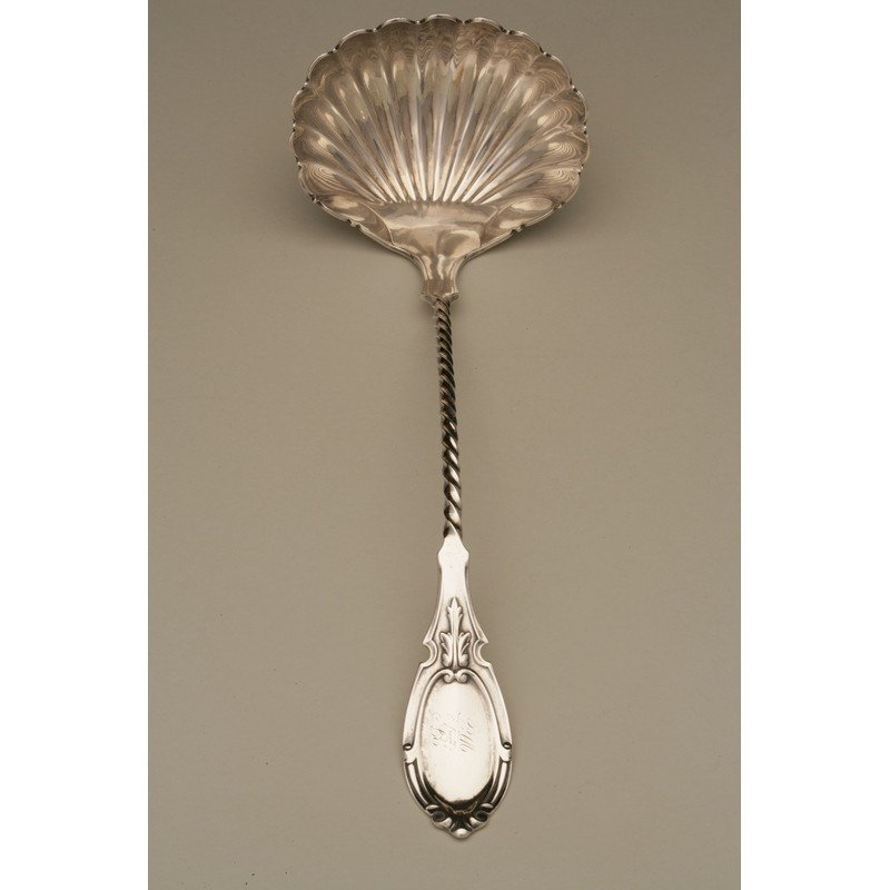 John W Tucker (1852-1886) Coin Silver Ladle: A coin silver twist handle ladle with scalloped bowl by John W Tucker, active 1852-1886, San Francisco, CA. Marks: COIN / star motif / J.W.TUCKER & CO Dimensions: 12.5"l Weight: 6 ozt 3.9 dwt Shippin