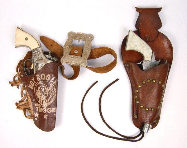Lot of 2 Roy Rogers Cap Guns & Holsters: Pistol in holster with fringe is marked "Trigger", has a crack in grip. Other Gun marked "Roy Rogers. Both are Very Good.