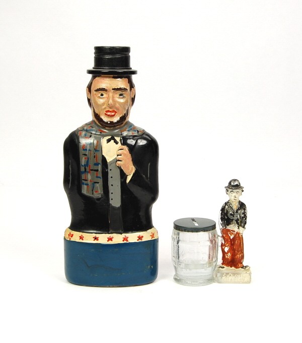 Lincoln Bottle & Charlie Chaplin c.c. Glass banks.: Glass & Tin. Lincoln - 8 1/2 in. Chaplin - 3 13/16 in.