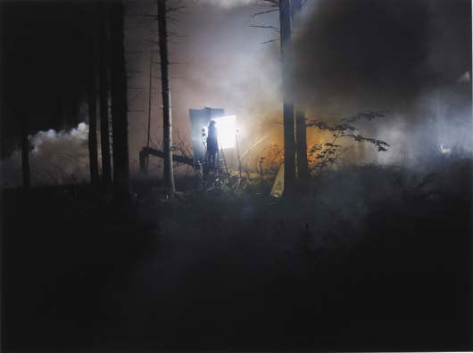 GREGORY CREWDSON, b. 1962: Production Still (Man in Woods#2, from Beneath the Roses), 2003 C-print. 12 x 16 in. (30.5 x 40.6 cm). Signed and dated lower edge. This work is from an edition of 20.