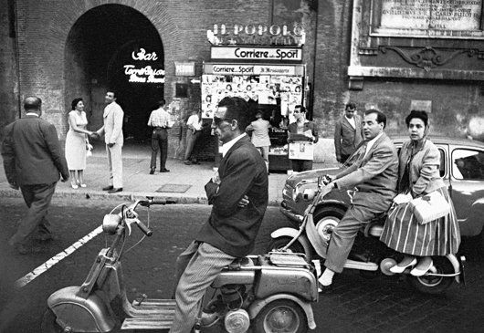 WILLIAM KLEIN, Red Light and Vespa, Rome, 1956: Red Light and Vespa, Rome, 1956 Gelatin silver print, printed c. 1970s. 23.2 × 35.6 cm (9 1/8 × 14 in). Signed, titled and dated in pencil on the verso. ♠ PROVENANCE Private Collection, Italy