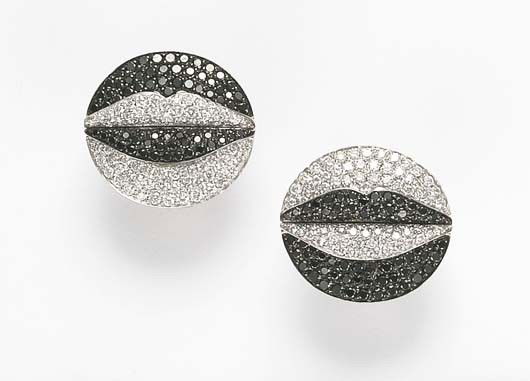 ENIGMA, A Pair of Diamond and Black Diamond 'Lips': A Pair of Diamond and Black Diamond 'Lips' Earclips Each designed as a circular plaque, set with pavé-set white and black diamonds, centering upon a lip motif, mounted in 18K white gold, 3/8 inches d