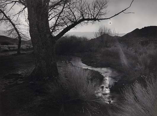 ANSEL ADAMS The Black Sun, Tungsten Hills, Owens V: The Black Sun, Tungsten Hills, Owens Valley, California, 1939 Gelatin silver print from Portfolio V, printed 1970. 13 5/8 x 18 3/8 in. (34.6 x 46.7 cm). Signed and numbered 'V-7- 27/110' in pencil on