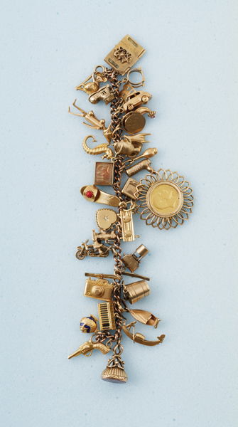 A Charm Bracelet and A Sovereign Pendant The 9 ct: A Charm Bracelet and A Sovereign Pendant The 9 ct yellow gold curb link bracelets suspending a plethora of mostly 9ct gold charms; together with a brooch–pendant containing sovereign dated 1910