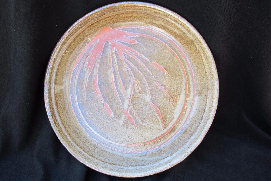 Pie Plate: This pie plate stoneware piece by artist Ray Kahmeyer features natural brown and red tones in the center. Measuring 10.5 inches in diameter this piece is in good condition.