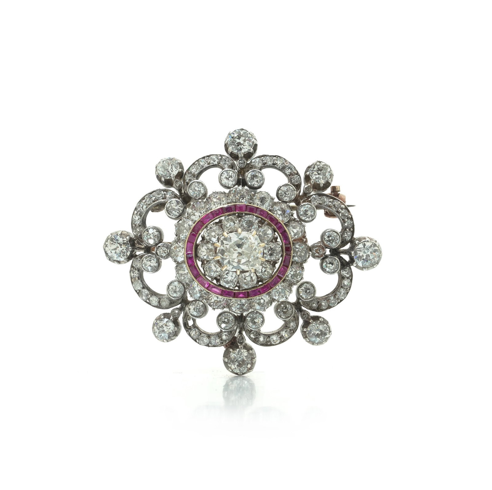 Antique Victorian Diamond and Ruby Brooch, 9ct Gold and Silver: A beautiful antique Victorian brooch in 9ct gold and silver, set throughout with old European-cut diamonds in an open scrolling foliate frame. The centre is set with an old cushion-cut diamond of appr
