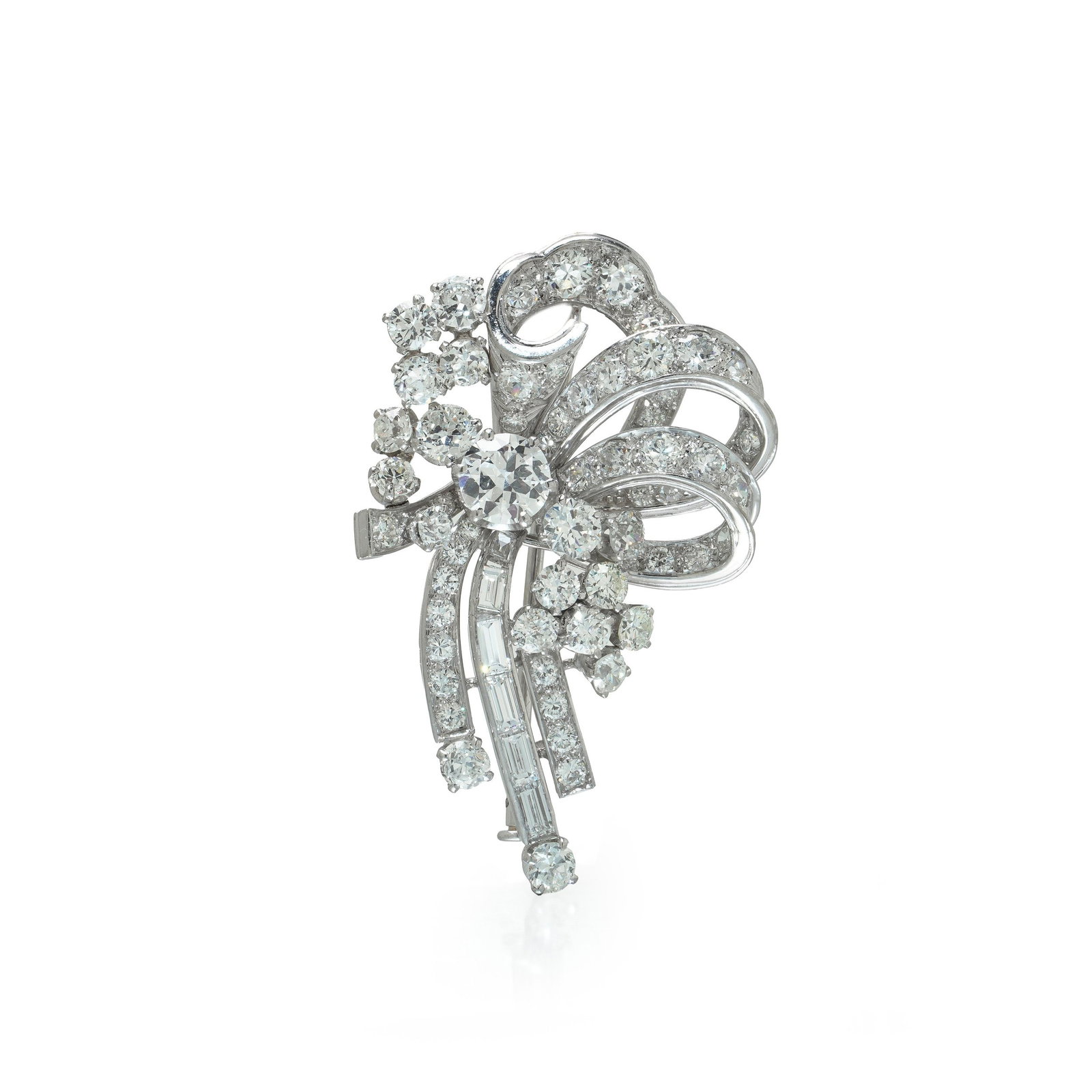Diamond Spray Brooch, Platinum, Circa 1950s: Diamond spray brooch in platinum, circa 1950s, a single larger diamond at the heart of a sculptural arrangement of looped ribbons and falling tassels. The design is worked in the round rather than fla