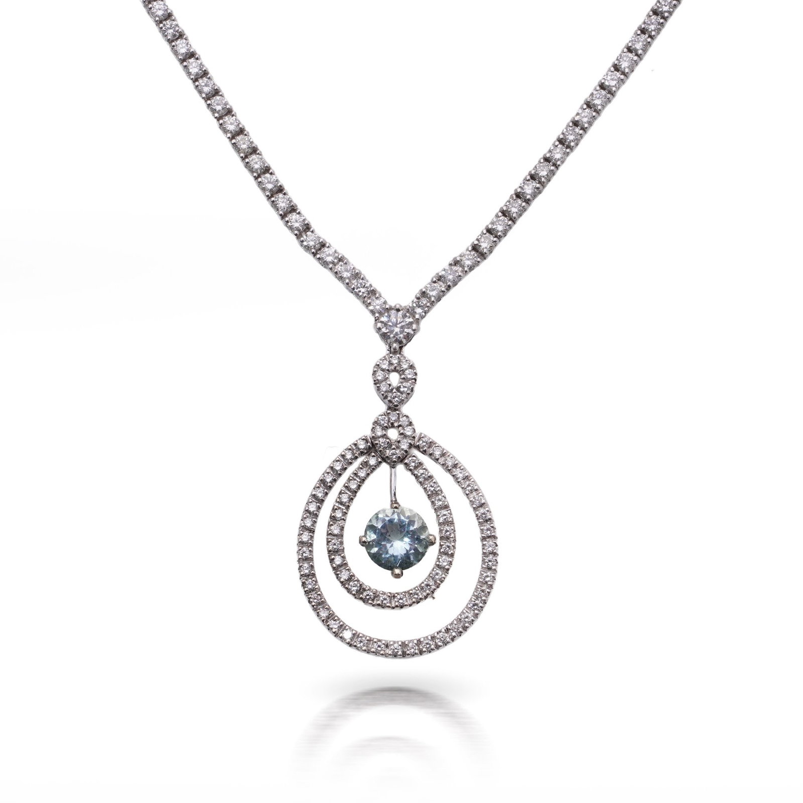Vintage 18KT White Gold Diamond & Aquamarine Necklace: A vintage necklace crafted in 18KT white gold, dating to the 1970s. The design features a diamond-set chain leading to a drop pendant, centred with a round-cut natural aquamarine. The aquamarine is fr
