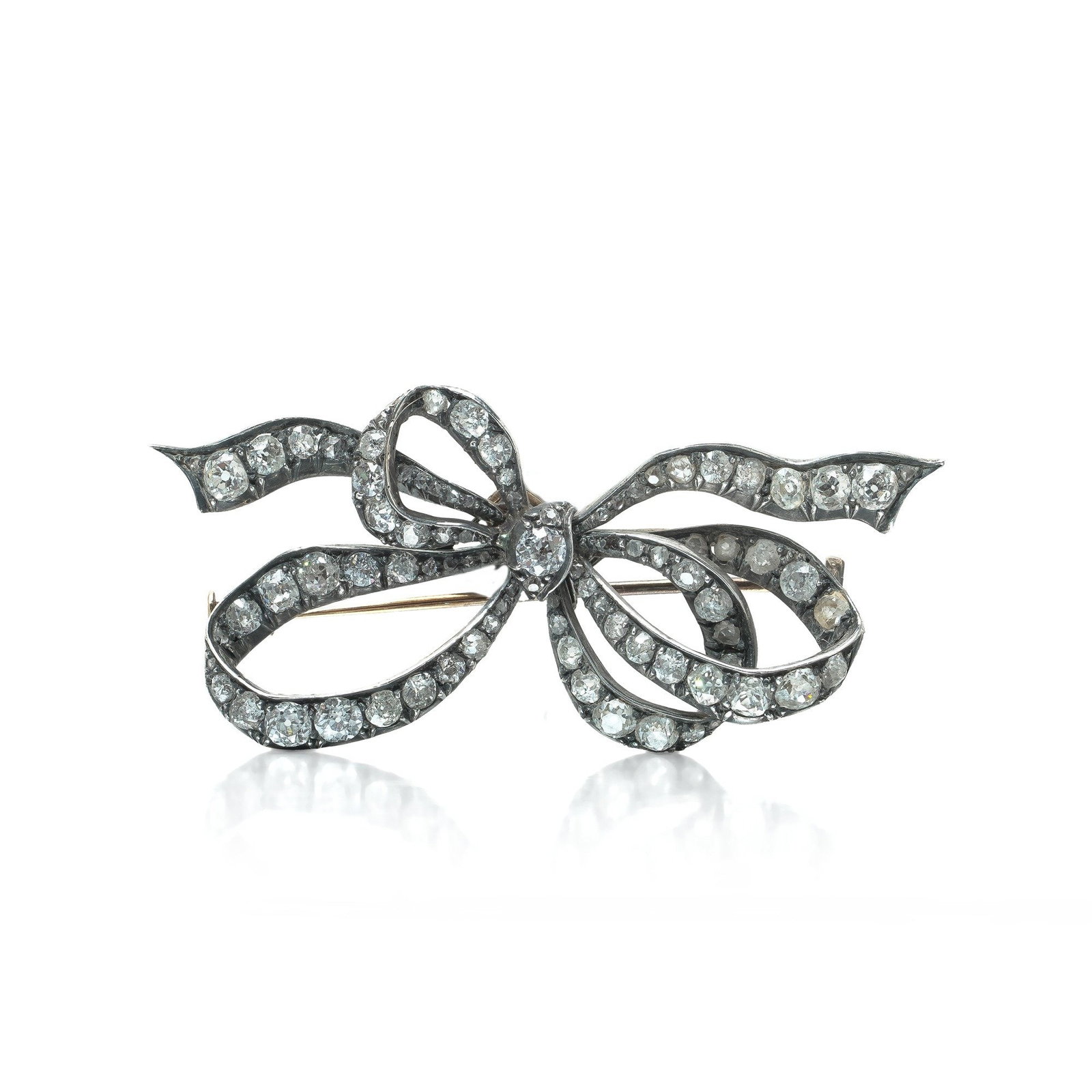 Victorian Old Cut Diamond Ribbon Bow Brooch, 4.00 ct, Silver Upon 9KT Gold: Victorian diamond ribbon bow brooch set with eighty one old cut diamonds totalling approximately 4.00 ct, the stones set in silver over a 9KT gold back, circa 1880. The ribbon bow was the Victorian je