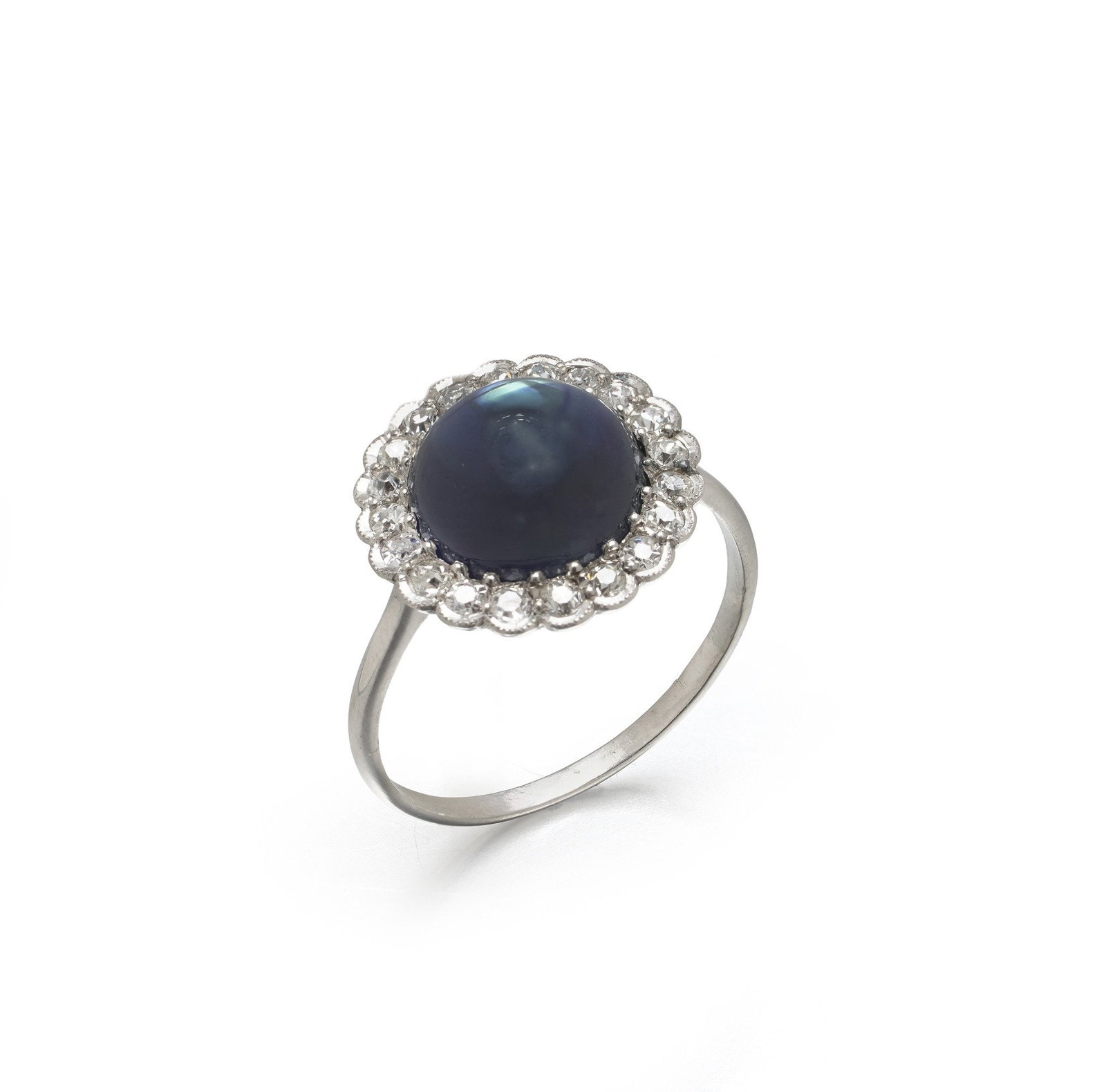 Art Deco Platinum Cabochon Sapphire & Diamond Cluster Ring, Approx. 4.00 ct: An Art Deco platinum ring centred on a cabochon natural sapphire of approximately 4.00 ct, encircled by twenty two old cut diamonds. The sapphire is cut as a high domed round cabochon in a deep blue, 