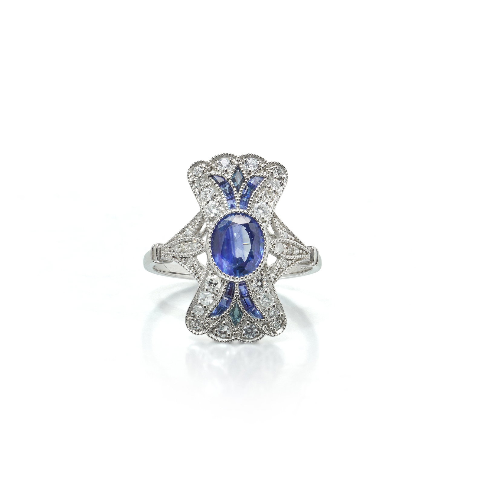 Art Deco Style Platinum 1.11 ct Sapphire and Diamond Bow Plaque Ring: Art Deco style platinum ring, the shaped plaque set with an oval sapphire of 1.11 ct between calibre cut sapphire fans above and below. The plaque is shaped like a bow or a spread fan, narrow at the w