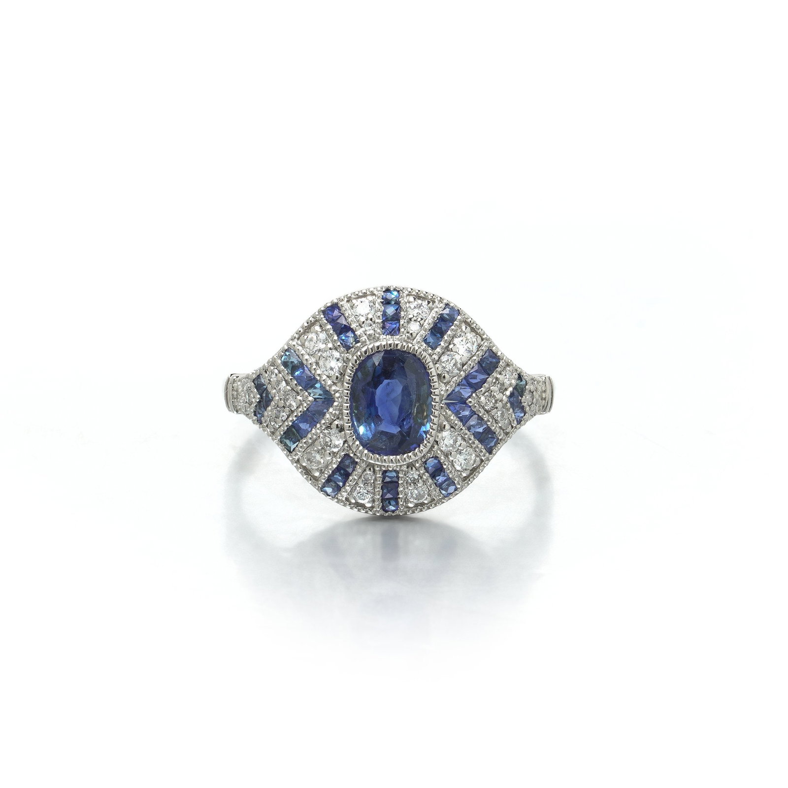 Art Deco Style Platinum Sapphire and Diamond Navette Ring, Rayed Setting: Art Deco style platinum navette ring , the oval sapphire centre framed by alternating rays of calibre cut sapphire and diamond. The plaque is a pointed navette. An oval sapphire is collet set across t