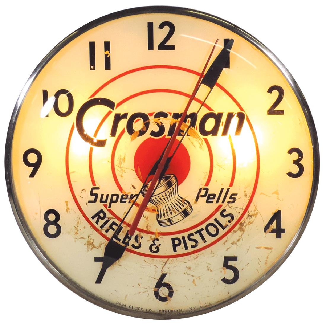 Advertising lightup clock, Crosman Rifles & Pistols,: Advertising lightup clock, Crosman Rifles & Pistols, mfgd by Pam, metal w/glass face, scratched face, o/wise VG wkg cond, 15"Dia.