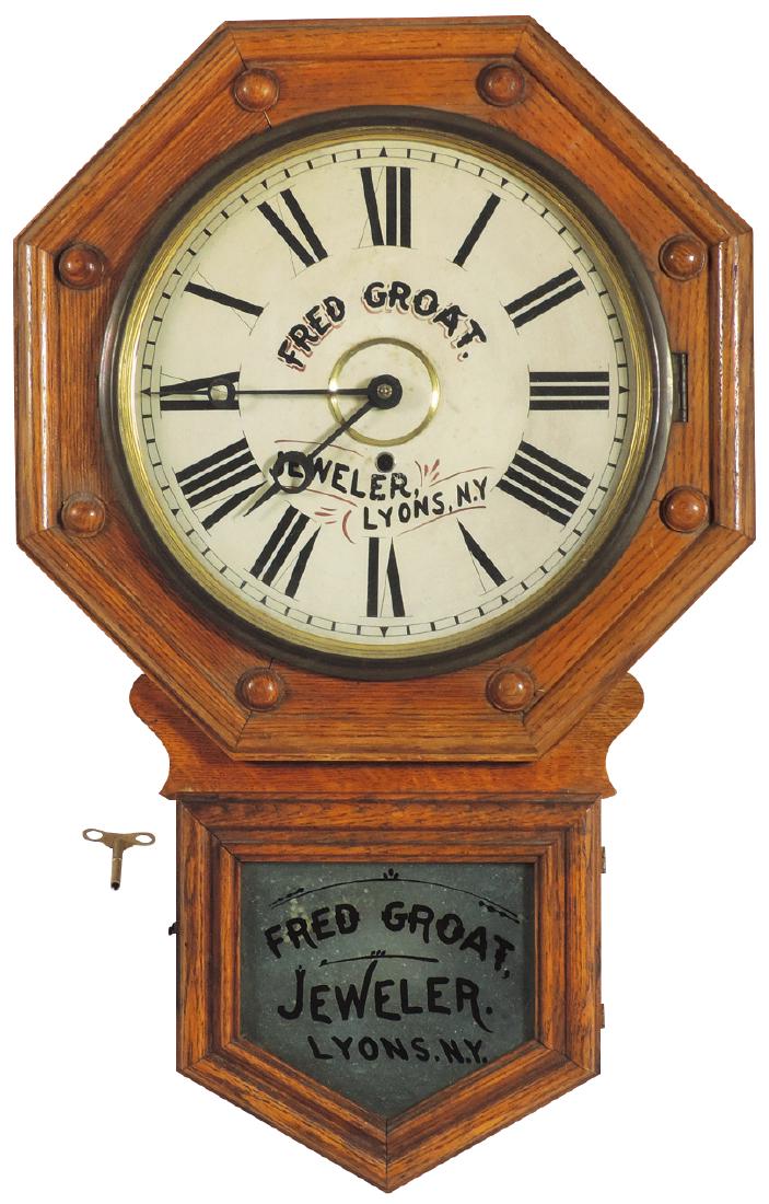 Clock, jeweler's regulator, mfgd by Gilbert w/adv from: Clock, jeweler's regulator, mfgd by Gilbert w/adv from Fred Groat Jeweler-Lyons, N.Y., oak case w/paper dial, Exc cond w/key, 27"L x 17"W.