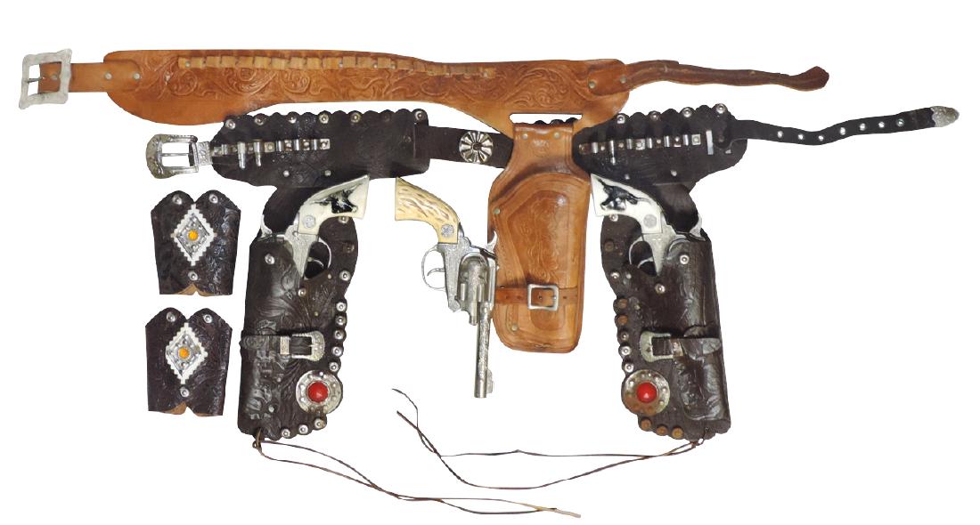 Toy cap guns & holsters (3), Hubley Texan Jr. double &: Toy cap guns & holsters (3), Hubley Texan Jr. double & single holster sets & pr tooled leather cuffs w/jewels, double holster & single holster Good wkg cond; cuffs VG cond.