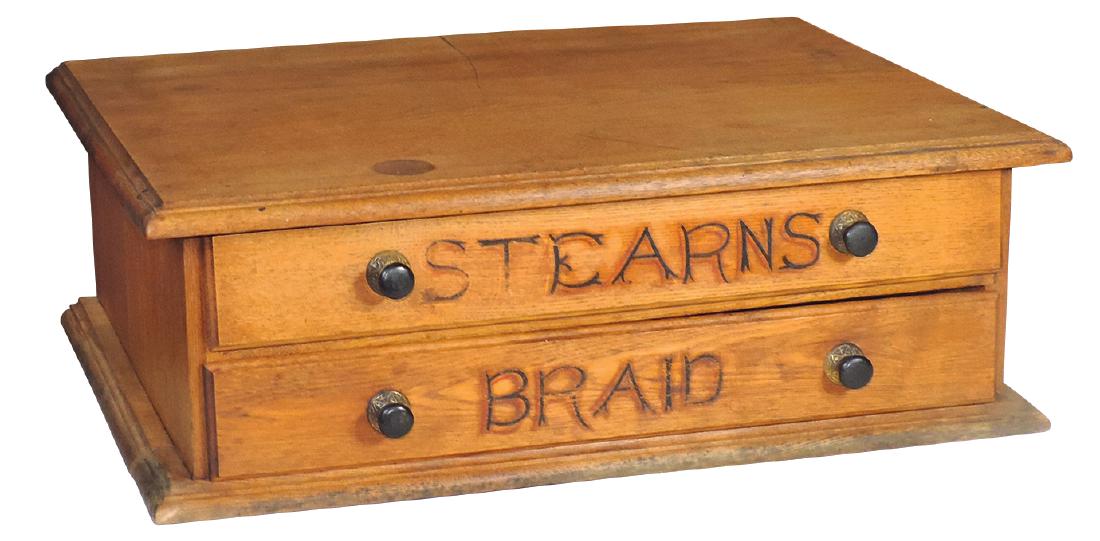 Country store Stearns Braid cabinet, oak 2-drwr w/orig: Country store Stearns Braid cabinet, oak 2-drwr w/orig metal & wood pulls, VG cond w/scratch & silver dollar sized stain on top, 9"H x 25.5"W x 17"D.
