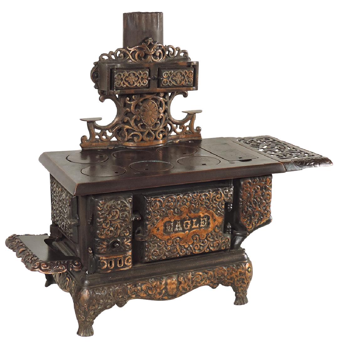 Salesman sample or child's stove, "Eagle" by Lancaster: Salesman sample or child's stove, "Eagle" by Lancaster Brand, copper-flashed cast iron 6-burner w/fretwork warming shelf, side hearth & chimney cabinet, c.1890, Exc cond w/orig flashing, 17"H x 21"W.