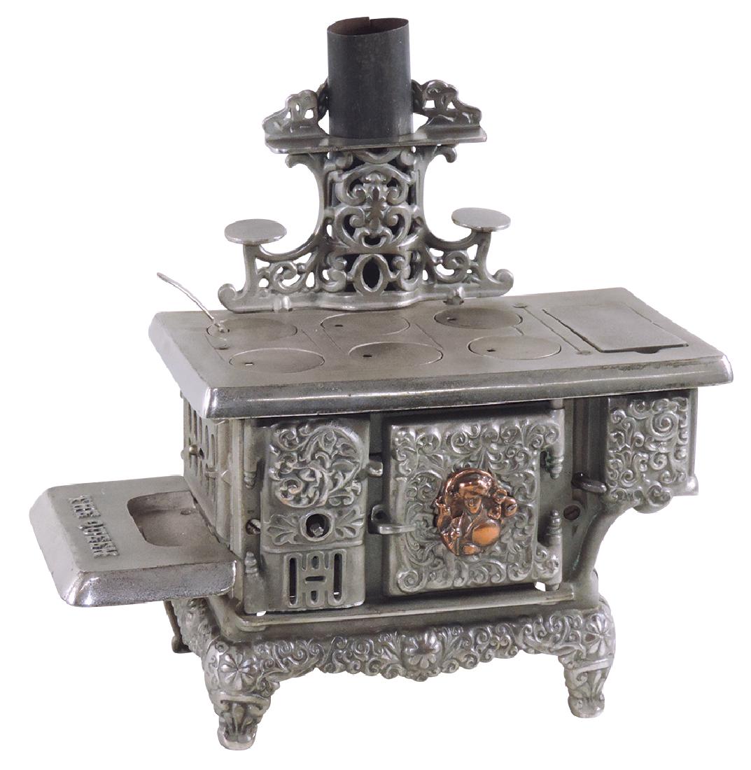 Salesman sample or child's stove, "The Queen", mfgd by: Salesman sample or child's stove, "The Queen", mfgd by Dent Foundry, extremely elaborate nickel-plated cast iron, fancy chimney cover w/teapot shelves, copper-plated medallion portraying a Japanese wo