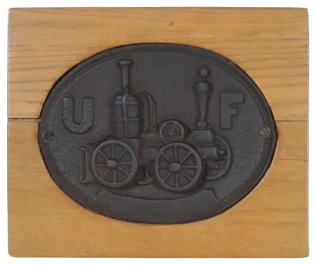 Fire mark, cast iron mounted on wood, embossed U F &: Fire mark, cast iron mounted on wood, embossed U F & pictures an early steam pumper, VG cond w/aged patina, c.1880's, 12.5"H x 14.75"W.