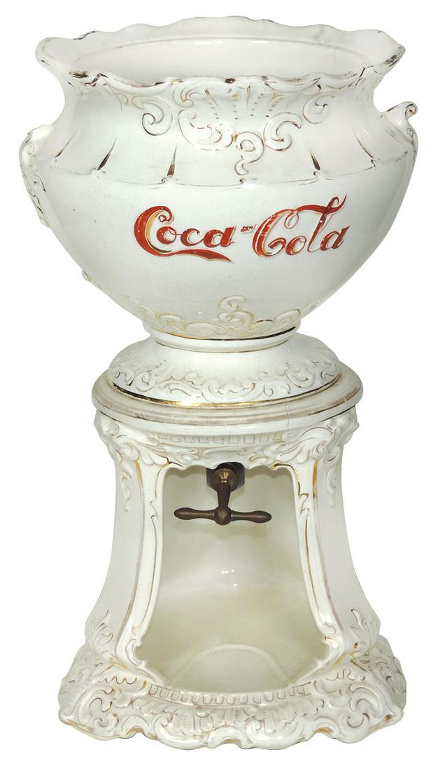Coca-Cola syrup dispenser, ceramic 2-pc urn, (missing: Coca-Cola syrup dispenser, ceramic 2-pc urn, (missing lid), mfgd by The Wheeling Pottery Co., c.1896, missing top of 1 handle & several tight old hairline cracks, orig spigot, VG cond & displays well,