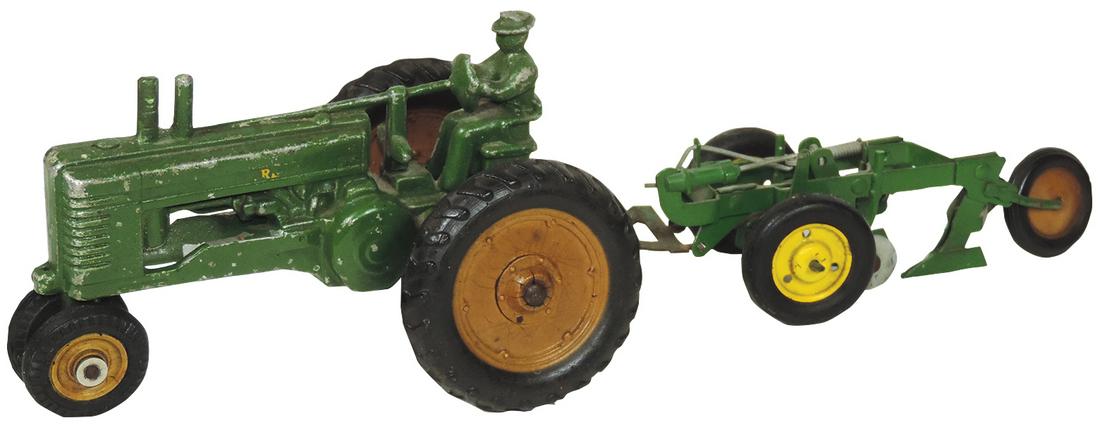 Farm Toys, John Deere A tractor w/driver, 1:16 Scale: Farm Toys, John Deere A tractor w/driver, 1:16 Scale Ertl, c.1940's, rubber wheels w/ribbed sides, front wheels marked Arcade, VG+-Exc cond w/minor paint & decal loss, comes w/John Deere 2-Bottom Plow