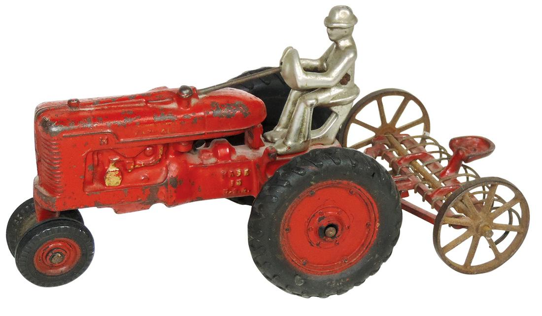 Farm Toys (2), Arcade McCormick Deering Farmall M: Farm Toys (2), Arcade McCormick Deering Farmall M tractor w/driver, decals mostly complete,nickel-plated driver, VG cond w/paint wear & Model 417 hay dump rake, c.1930's, Exc cond, both stamped, "Arca