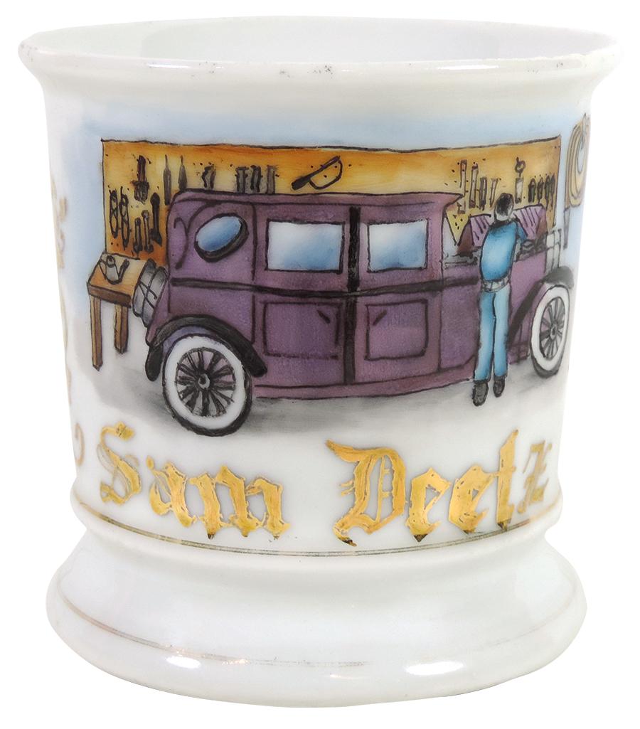 Occupational Shaving Mug, Mechanic, working on auto: Occupational Shaving Mug, Mechanic, working on auto w/hood up, many tools & hose on wall, bottom stamped Germany, personalized Sam Deetz, nice image, Exc+ cond w/minor wear on bottom gold bands, 3 75"