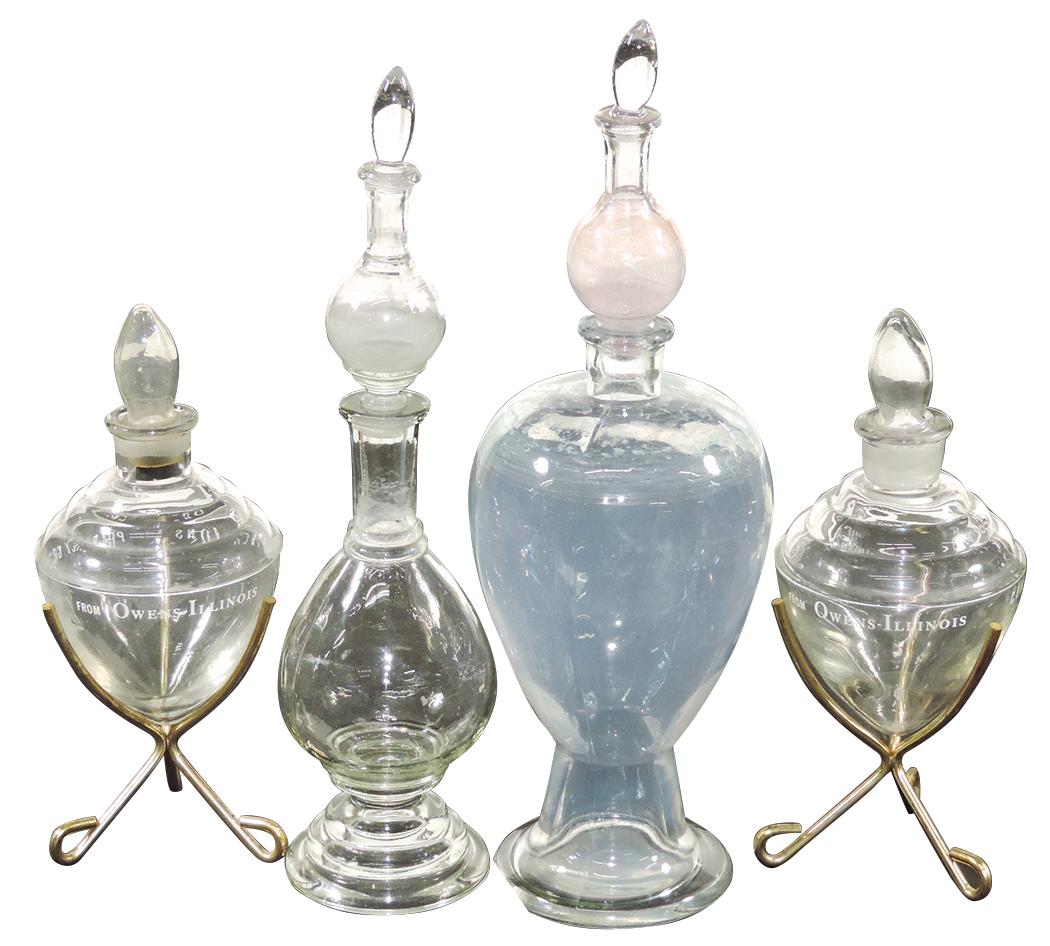 Apothecary Show Jars (4), two glass pear-shaped jars: Apothecary Show Jars (4), two glass pear-shaped jars w/secondary jar form stoppers & two Owens Illinois "Pharmacy Graduate 1962" jars in metal stands, 1 Owens stopper has loss to peg, largest secondar