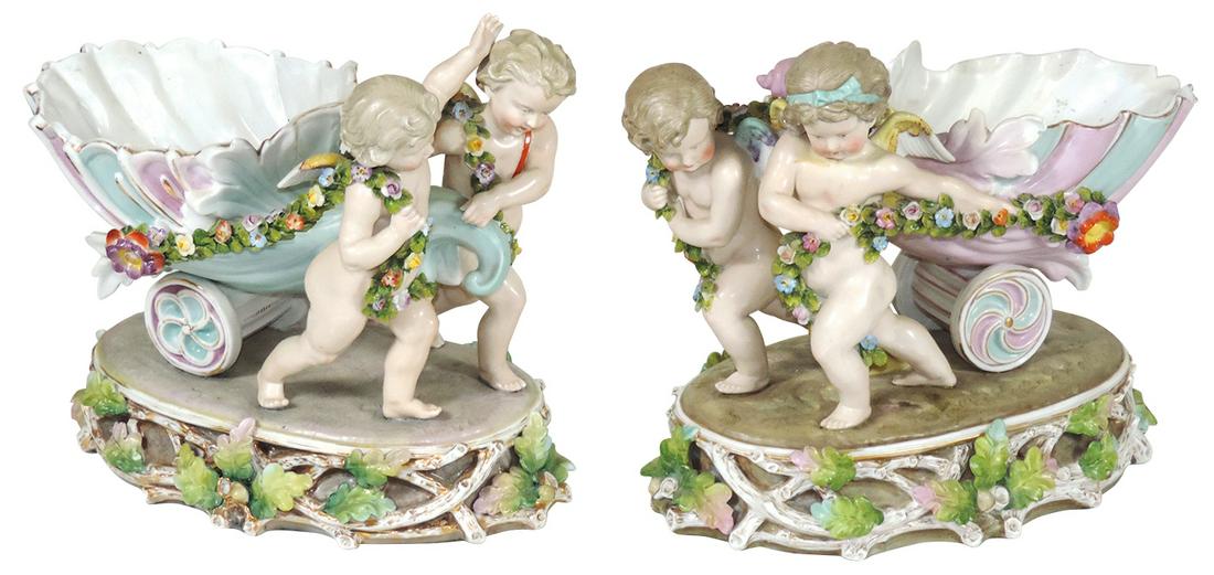 Decorative Volkstadt Figural Cherubs Porcelain: Decorative Volkstadt Figural Cherubs Porcelain Centerpieces, circa 1880, each depict pulling a wheeled cornucopia w/floral garland, Crossed Blue Sword marks of 1880-1884, VG to Exc cond, 10"H x 9.5"W.
