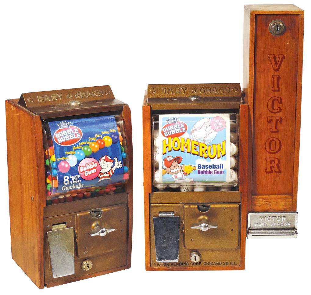 Coin-Operated Baby Grand 5 Cent Gum Vendors (2), mfgd: Coin-Operated Baby Grand 5 Cent Gum Vendors (2), mfgd by Victor Vending Corp., c.1950s, oak & die cast metal, one w/side "card vendor" (card mechanics absent), Good & VG working cond unless noted & w/