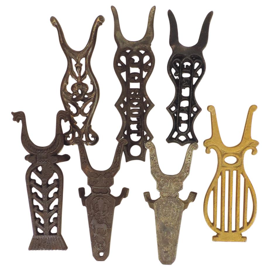 Bootjacks (7), all vintage cast iron in different forms: open lettered "Try Me" & "J. G. Scott",: Bootjacks (7), all vintage cast iron in different forms: open lettered "Try Me" & "J. G. Scott", cornflower, 2 w/donkeys, open scroll & lyre, most VG or VG+ cond, largest 13.5"L.