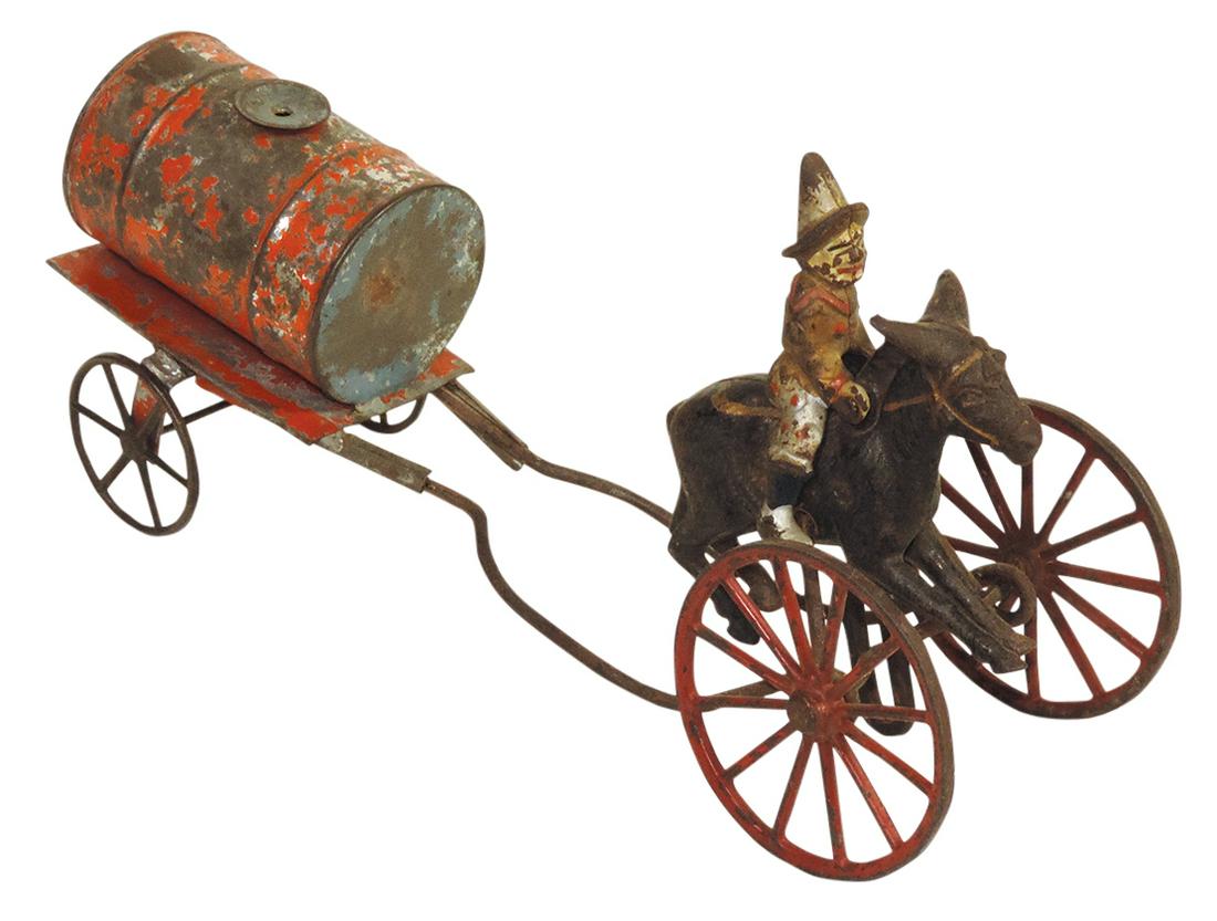 Toy Fireman on Balky Mule with Water Cart, cast iron & tinplate, late 19th C., Good+ cond w/remnants: Toy Fireman on Balky Mule with Water Cart, cast iron & tinplate, late 19th C., Good+ cond w/remnants of paint, early repair to undercarriage & draw bars detached, 10.5"L.