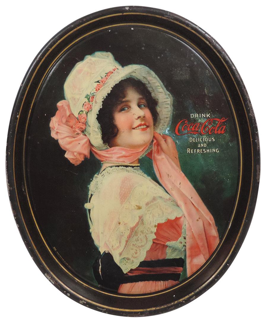 Coca-Cola Serving Tray, c.1914 "Betty", litho on metal marked Stelad Signs Passaic Metal Ware: Coca-Cola Serving Tray, c.1914 "Betty", litho on metal marked Stelad Signs Passaic Metal Ware Works-Passaic, NJ, an early oval tray w/VG color & gloss, Good+ to VG cond w/some wear, 15.25"H x 12.5"W.