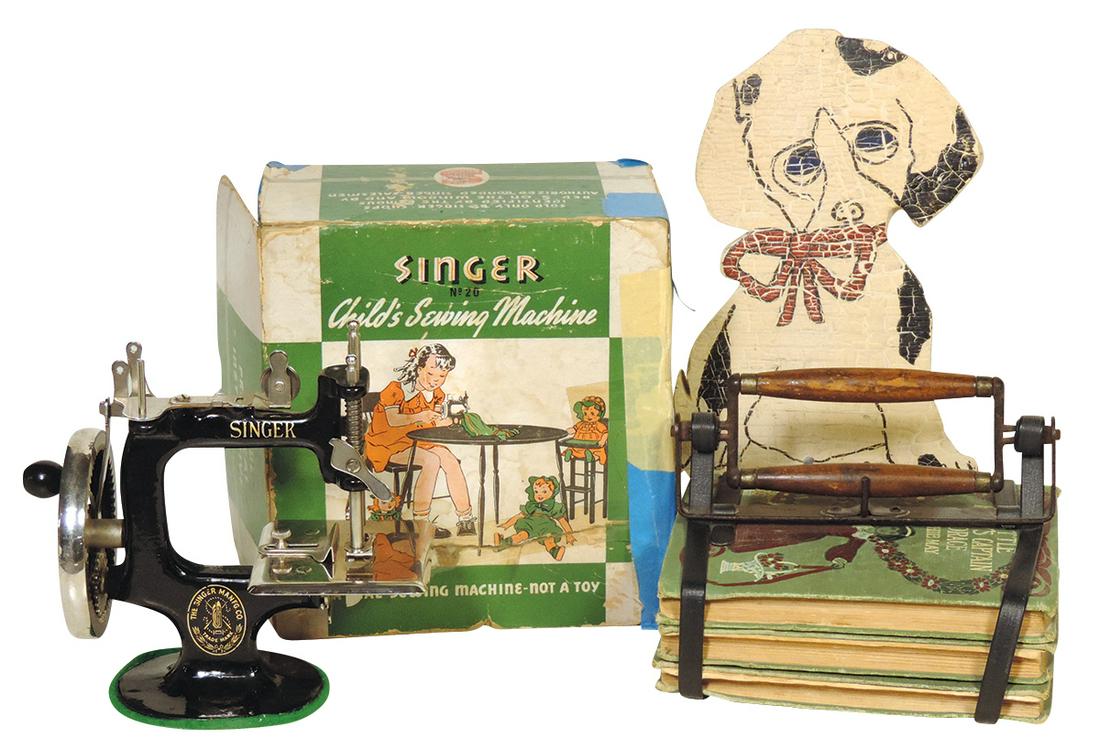 Toys (3), Singer Sewing Machine (Exc+ cond in box), pat. book carrier w/3 Sophie May books & painted: Toys (3), Singer Sewing Machine (Exc+ cond in box), pat. book carrier w/3 Sophie May books & painted wood Puppy door wedge, wear & loss to box, o/wise VG to VG+ cond, largest 9"H.