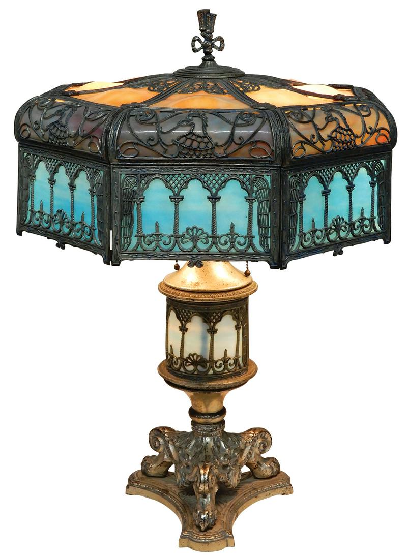 Lighting, Slag Glass Table Lamp, attributed to Miller, 24 glass sections in variegated amber, purple: Lighting, Slag Glass Table Lamp, attributed to Miller, 24 glass sections in variegated amber, purple & blue opalescent glass under scrolled filigree w/ Eagle heads, matching lighted claw-footed base w