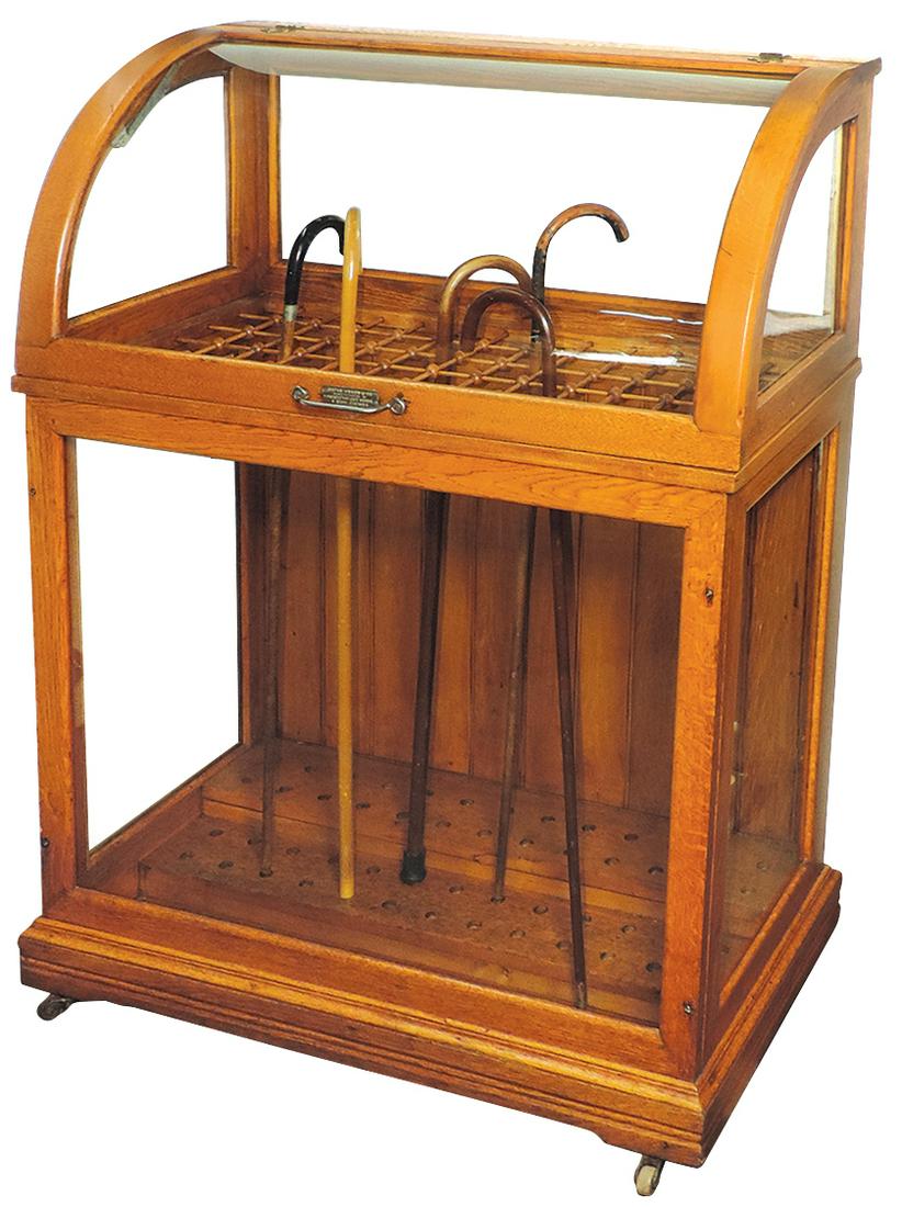 Country Store Cane Case, oak w/curved glass lift top & glazed side panels, mfgd by Oscar Onken &: Country Store Cane Case, oak w/curved glass lift top & glazed side panels, mfgd by Oscar Onken & Co.-Cincinnati, OH w/stick & ball divisions for 78 canes, Exc refinished cond, 48"H x 36"W x 19"D.