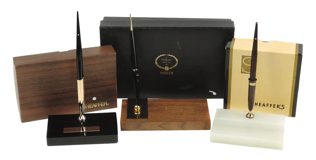 Pen Desk Sets (3), 2 Sheaffer White Dot, 1 w/black onyx & ballpoint pen, other white onyx w/brown: Pen Desk Sets (3), 2 Sheaffer White Dot, 1 w/black onyx & ballpoint pen, other white onyx w/brown lacquer trumpet & fountain pen w/14k gold nib, together w/Parker set, walnut, all NOS cond in orig box