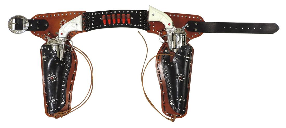 Toy Cap Pistol & Holster Set, pair Stallion 45 six shooters, mfgd by Nichols, die-cast, in stitched,: Toy Cap Pistol & Holster Set, pair Stallion 45 six shooters, mfgd by Nichols, die-cast, in stitched, studded & jeweled double holster w/belt, Exc working cond, noting chip on 1 grip, 15"H x 36"W.