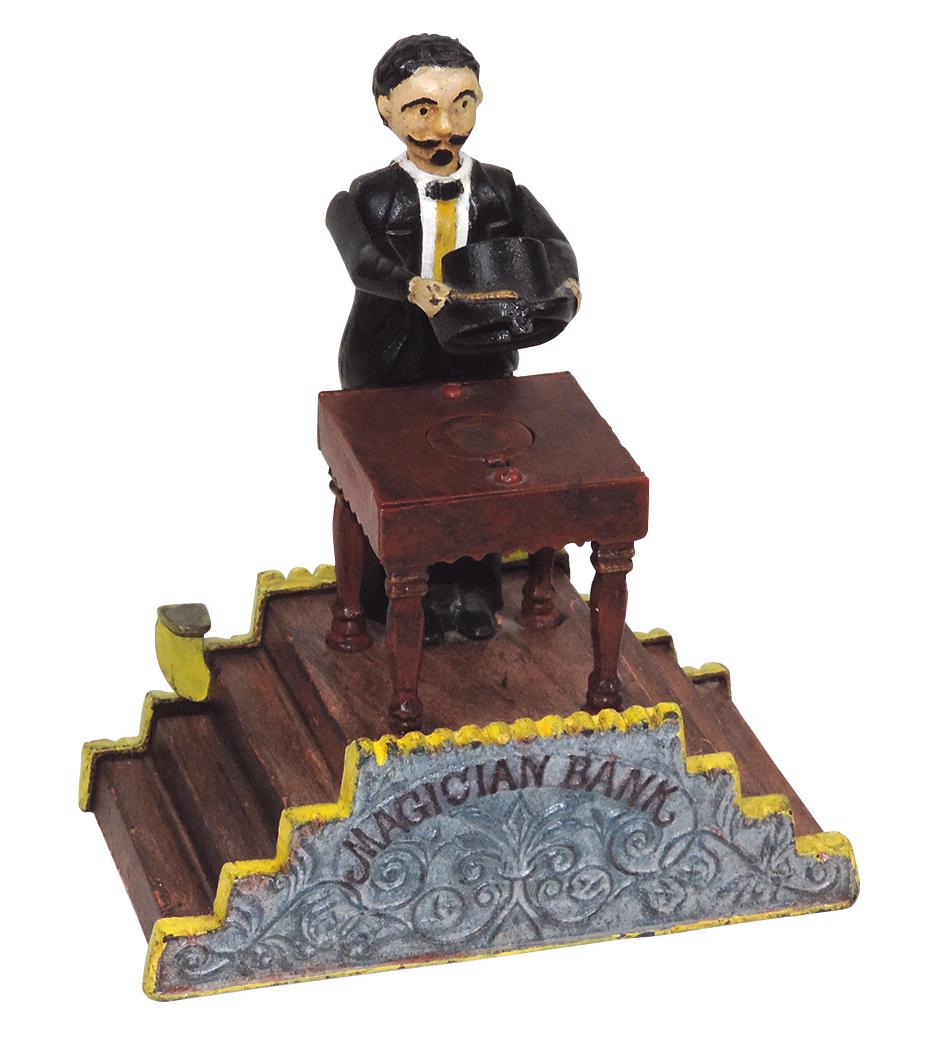 Mechanical Bank, Magician, mfgd by J. & E. Stevens, cast iron, c.1901, place coin on table, press: Mechanical Bank, Magician, mfgd by J. & E. Stevens, cast iron, c.1901, place coin on table, press lever, hat drops & coin disappears, Exc working cond w/prof repaint, 8"H.