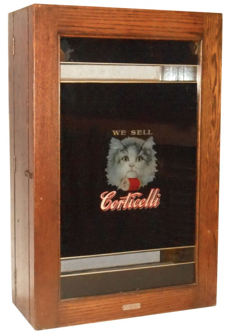 Spool cabinet, Corticelli, oak, reverse transfer : Spool cabinet, Corticelli, oak, reverse transfer on glass reads "We Sell Corticelli" w/the Corticelli Cat pictured on both sides of cabinet, orig maker's tag reads "US Patents June 13, 1905", doors op