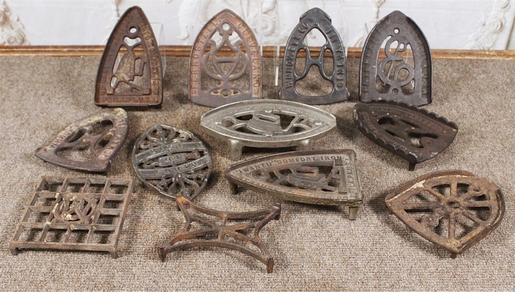 Collection of 12 assorted cast iron sad iron trivets, mostly VG cond, largest 7"L.: Collection of 12 assorted cast iron sad iron trivets, mostly VG cond, largest 7"L.